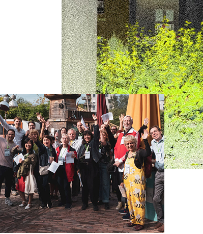 Group 28 - URBAN UTOPIA Gruppe von Menschen, die in einem Freiluftbereich stehen und fröhlich die Hände heben.